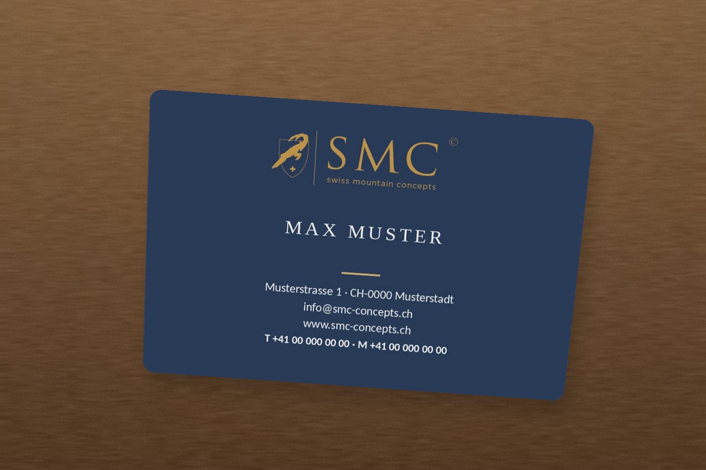 Visitenkarte SMC swiss mountain concepts – Corporate Design in Navy und Gold, Mockup auf Holz